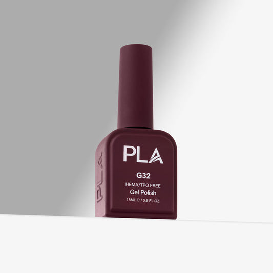 A bottle of PLA G32 HEMA/TPO Free Gel Polish in a deep burgundy shade, standing upright on a white surface against a gray background.