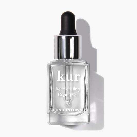 A pristine white background showcases a clear glass bottle with a black dropper cap, labeled "Accelerating Drying Oil by LONDONTOWN." This fast-drying manicure botanical oil blend is designed for optimal performance.