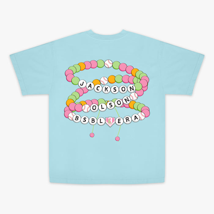 Light blue t-shirt with colorful letter beads and "Jackson Olson BSBL Era" text design on a white background