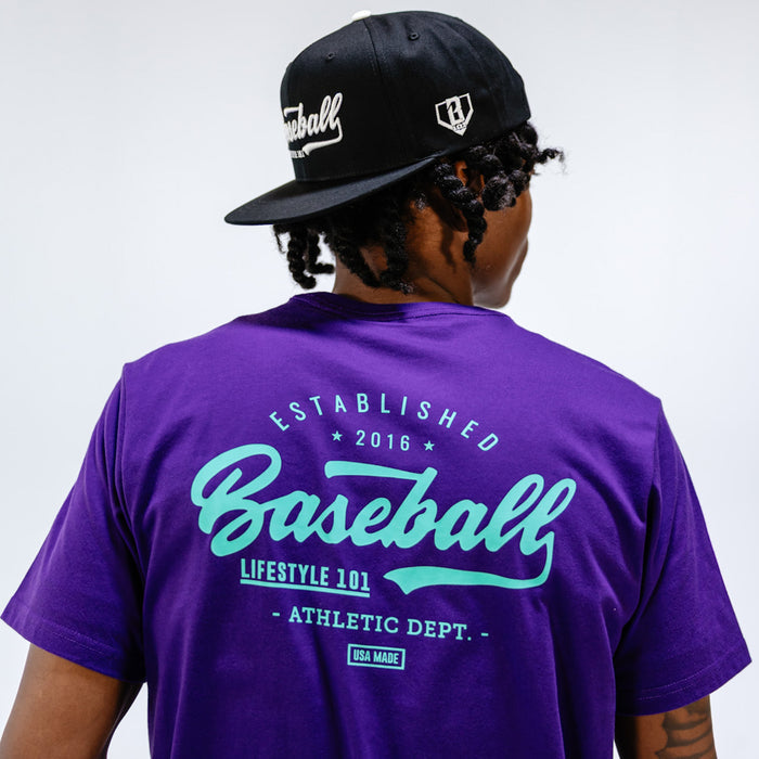Adult model wearing purple and teal Established graphic tee
