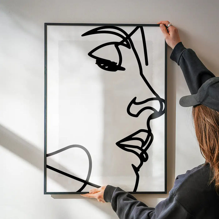 Face Close Up Line Art Print being hung on a wall in a black frame