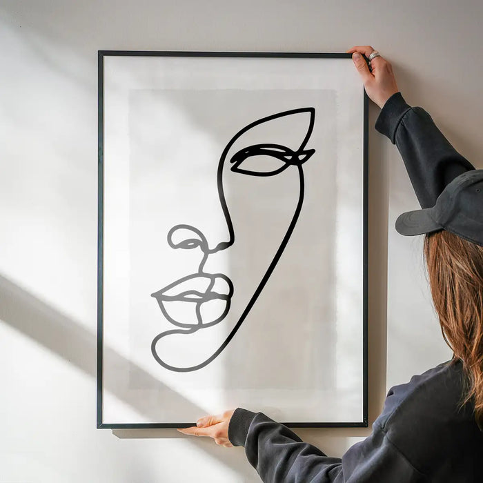 Face Study Line Art Print being hung on a wall in a black frame