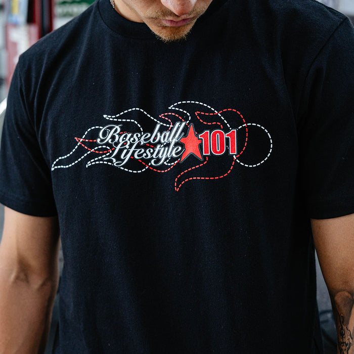 Close-up of stitched white and red Baseball Lifestyle 101 flame chest graphic on black tee.