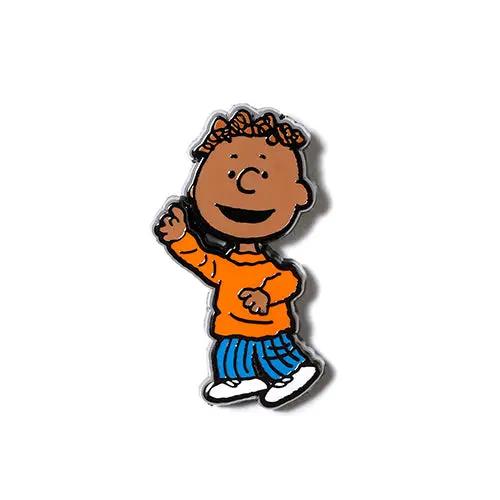 Smiling cartoon kid enamel pin with orange top, blue striped pants, and white shoes.