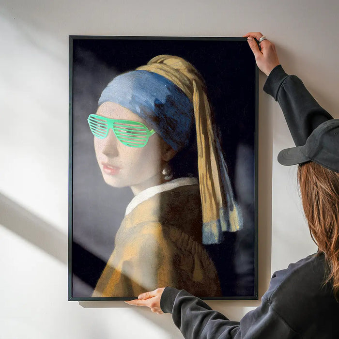 Girl With Green Shutter Shades Print being hung on a wall in a black frame