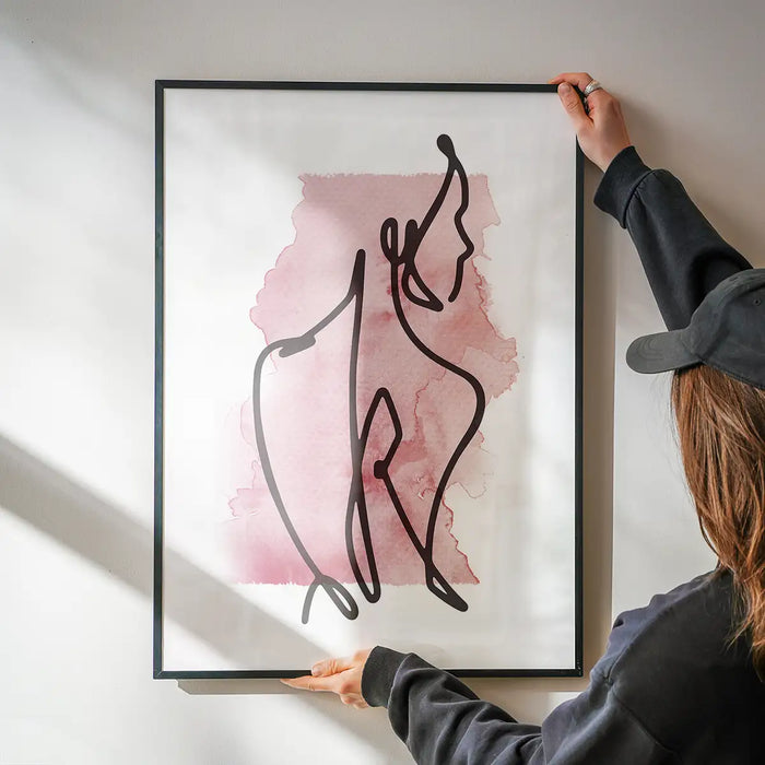 Glancing Watercolour Line Art Print being hung on a wall in a black frame