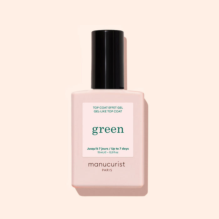 A bottle of Manucurist Green Sunshine Top Coat comes in a pale pink rectangular bottle with a black cap and white label, offering a gel-effect finish with its plant-based formula.