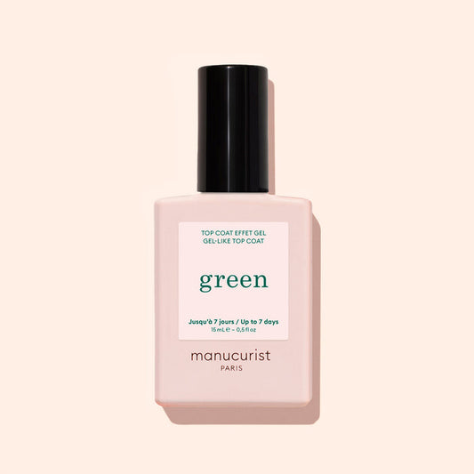 A bottle of Manucurist Green Sunshine Top Coat comes in a pale pink rectangular bottle with a black cap and white label, offering a gel-effect finish with its plant-based formula.