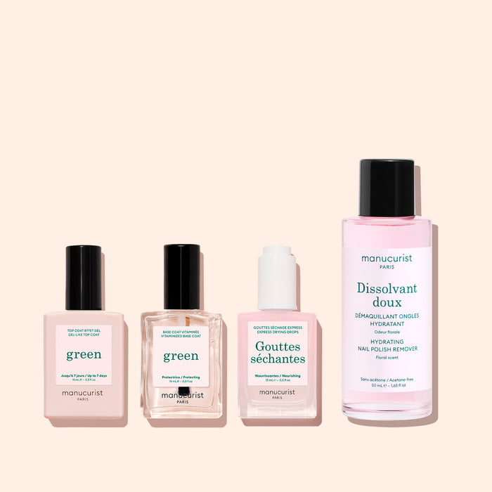 Four Manucurist manicure products in pink bottles—labeled Green, Gouttes Sèchantes, Dissolvant Doux, and Sunshine Top Coat—stand in a row against a light pink background. Each bottle features a white label with teal text that highlights its plant-based formula and promises a glossy gel-effect finish. The Sunshine Top Coat is part of the Green range by Manucurist.
