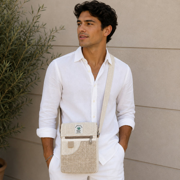 Man wearing a white shirt with a beige crossbody bag against a neutral background