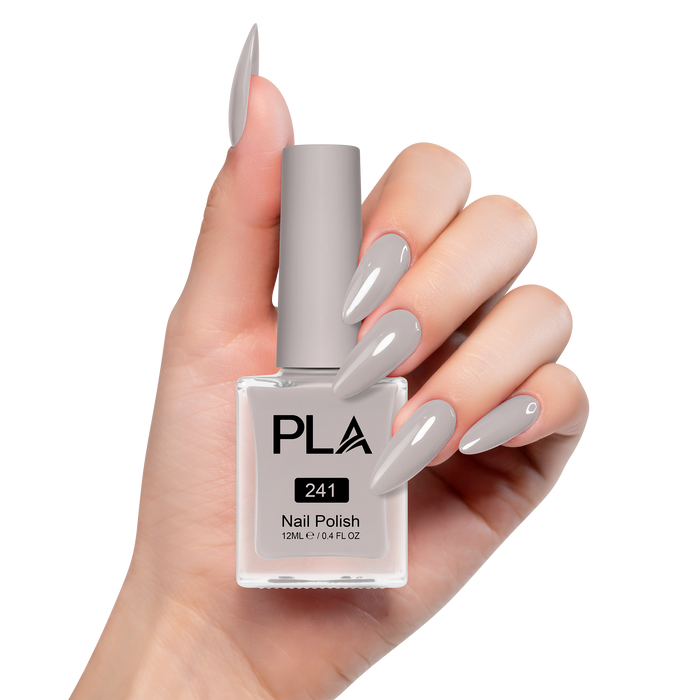Hand holding a bottle of PLA nail polish with matching nails on a white background