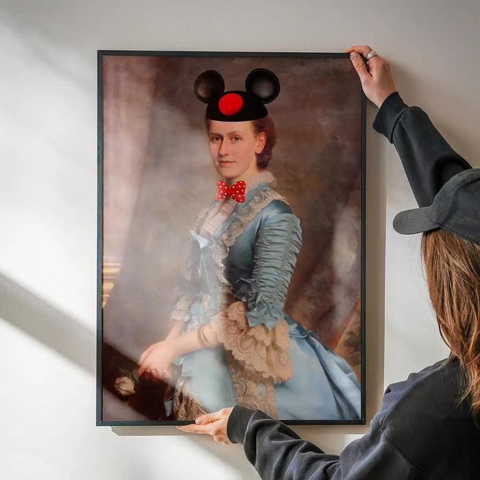 Lady With Minnie Ears Print being hung on a wall in a black frame