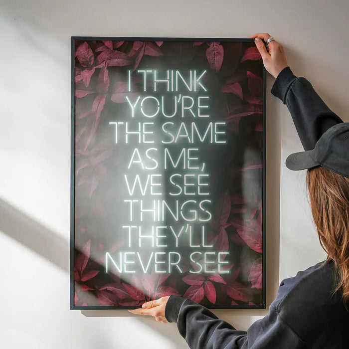 Live Forever Lyrics Print being hung on a wall in a black frame