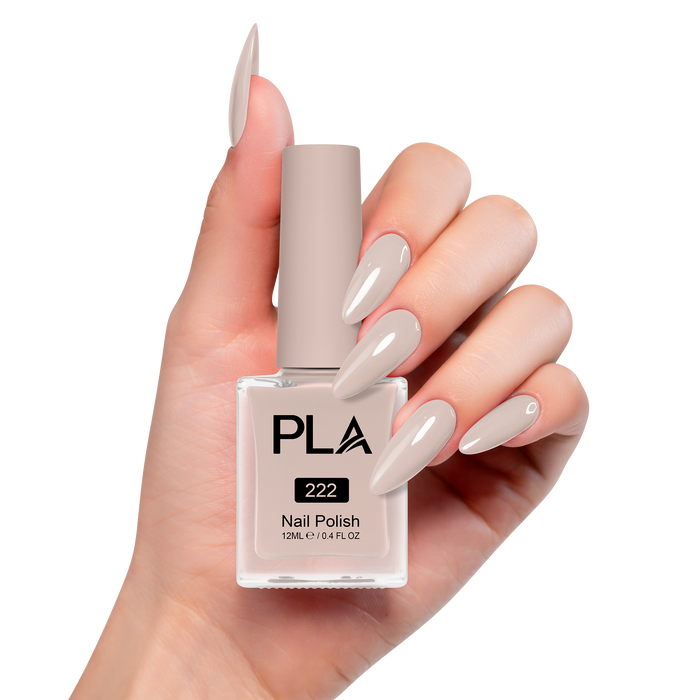 Hand holding a brown nail polish bottle with matching nails on a white background