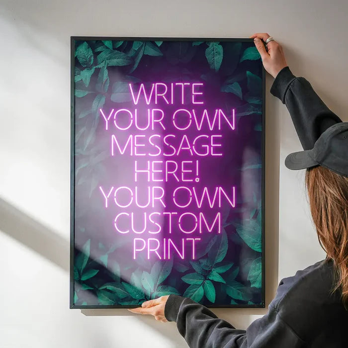 Pink Neon Centered Leaves Print being hung on a wall in a black frame