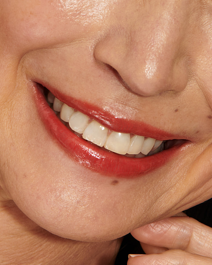 Close-up of a model's mouth with Red Curve Baume Embrace