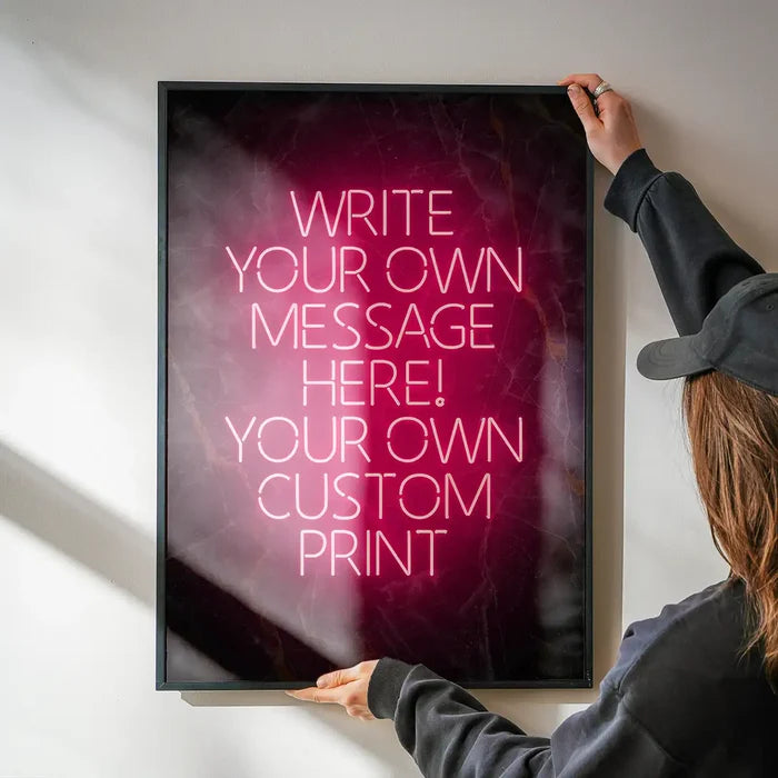 Red Neon Centered Black and Gold Print being hung on a wall in a black frame