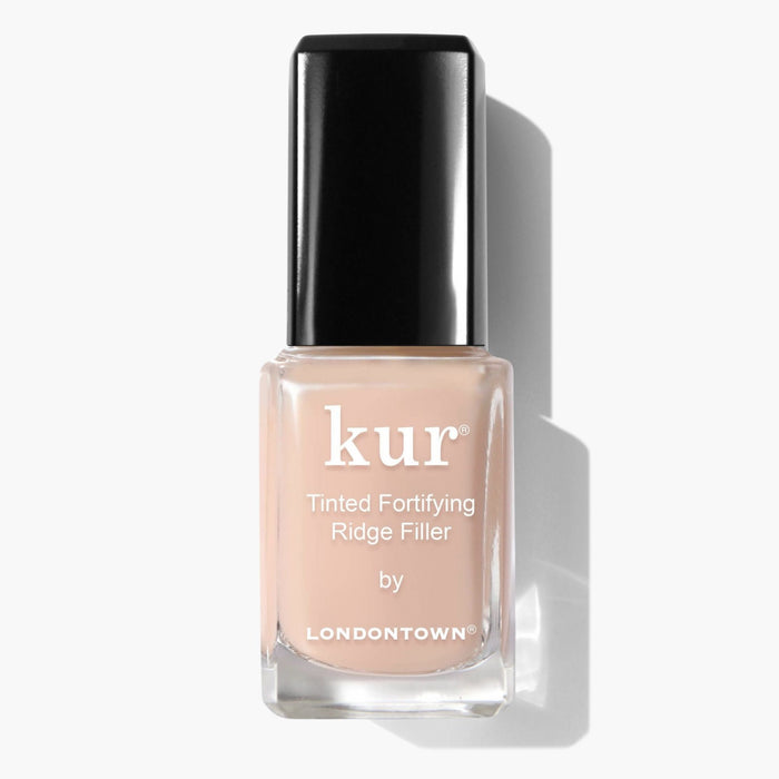 Square bottle of LONDONTOWN's Tinted Fortifying Ridge Filler in Apricot Beige, features beige polish for smoothing ridges, topped with a black cap casting a rightward shadow.