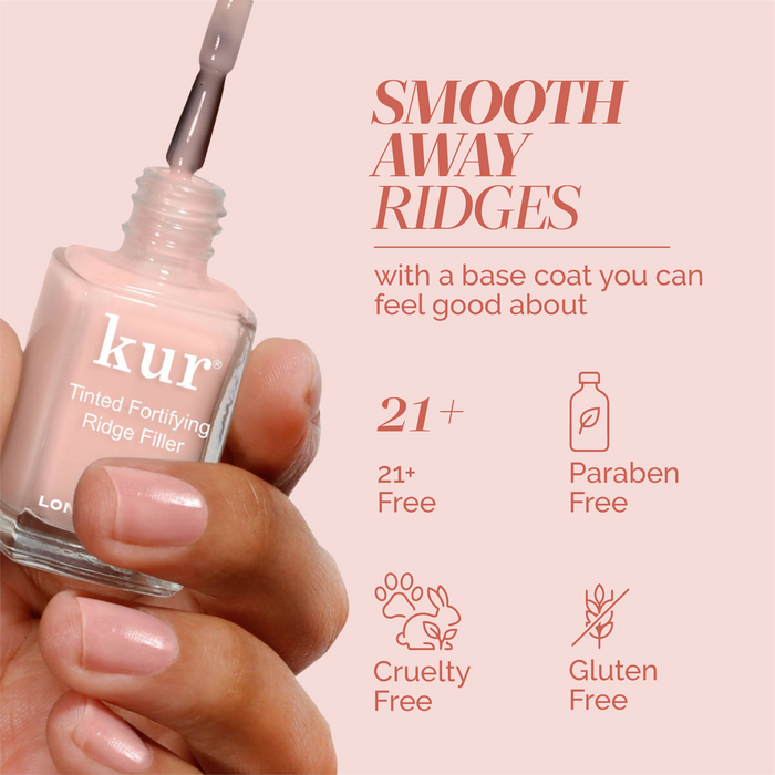 A hand holds LONDONTOWN's Tinted Fortifying Ridge Filler - Petal Pink, a 21+ free, paraben-free, cruelty-free, and gluten-free nail polish that smooths ridges and adds a hint of tint.